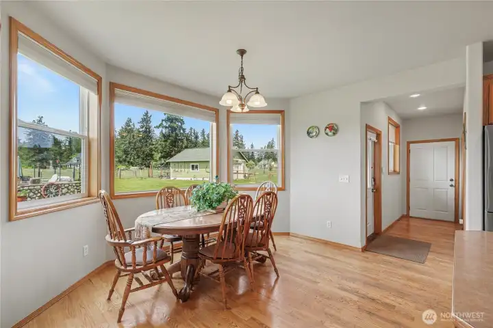 Eat-in kitchen view, the bay windows are incredible! You can see your firepit/patio area and shop, down the hall is your garage entry for a short grocery commute!