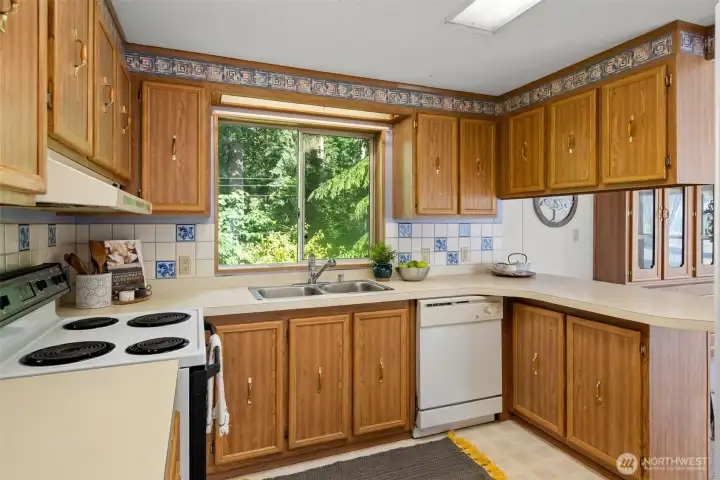 With the sink and dishwasher facing the forested backdrop, even the everyday kitchen tasks become light and easy with this peaceful view.