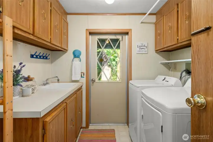 Laundry may still be laundry, but this room makes it so much easier with all the goodies: a folding area, utility sink, tons of cabinetry, a hanging rod overhead, and a full-size washer and dryer!