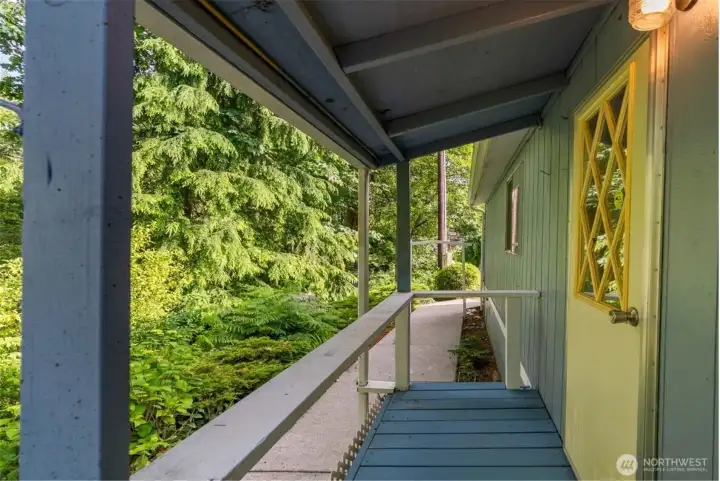 Step out from the laundry room and this sweet covered porch gives you a quiet little perch for taking in the forest view and unwinding for a minute.