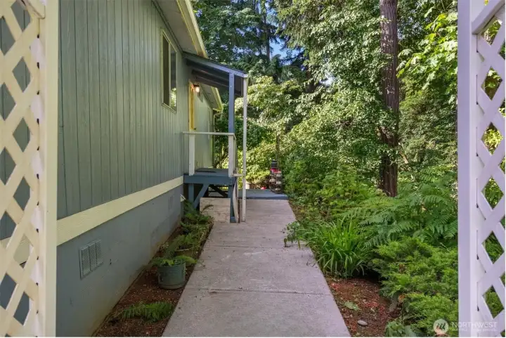 This side of the home has such a sweet garden feel, with two trellises along the walkway, including the white one in the foreground and a beautiful flowering honeysuckle at the end of the sidewalk.