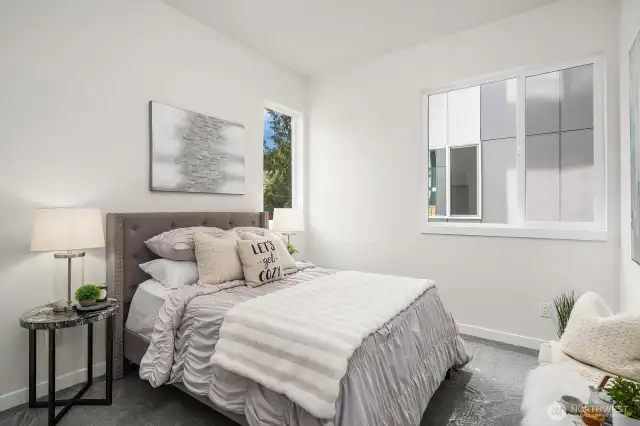 A serene retreat, this inviting bedroom is perfect for guests. With soft hues and expansive windows, it offers a luminous, airy sanctuary where comfort reigns supreme. (Photos are of staged model home.)