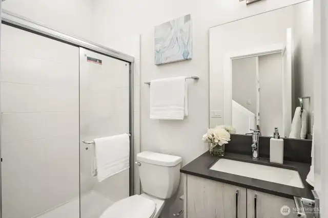 Indulge in a spa-like retreat with this luxurious bathroom, where thoughtful design meets modern elegance. A rain shower, and sleek vanity, complete the serene experience. (Photos are of staged model home.)