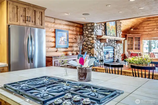 A view of the great room and faux river rock fireplace from the kitchen.
