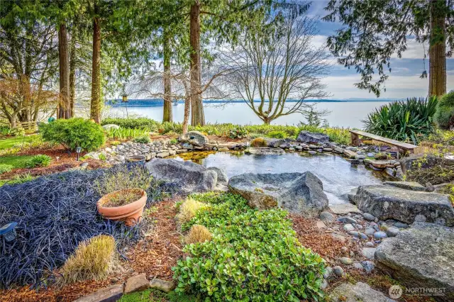 Stunning 2.5 acre homesite has lush gardens, re-circulating waterfall & pond, & incredible water & mountain views!