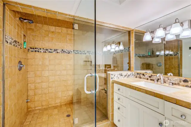 The primary ensuite has two separate vanities and this spacious steam shower!