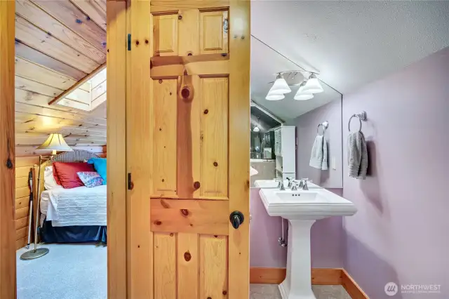 View of the beautiful 3/4 bath and sleeping area in the loft bedroom. Furnishings in the loft convey.