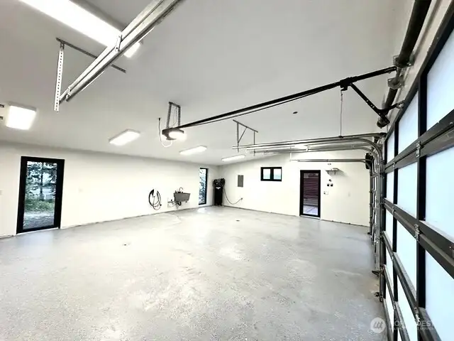 Bright and open garage with ample work space and room for the toys. Electric car charger