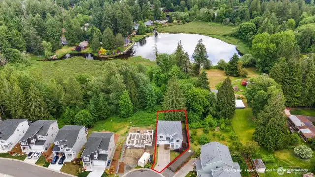 aerial view of the home and lake behind it. The area behind the home is protected land & cannot be built on!