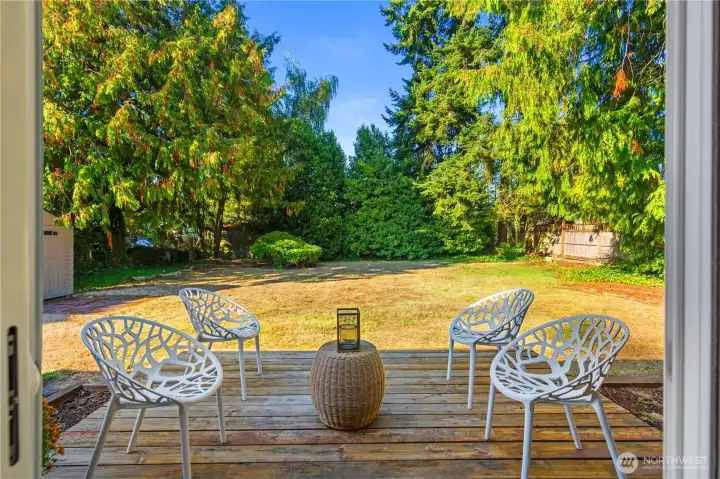 The extended outdoor living space with a flat, fully fenced yard.