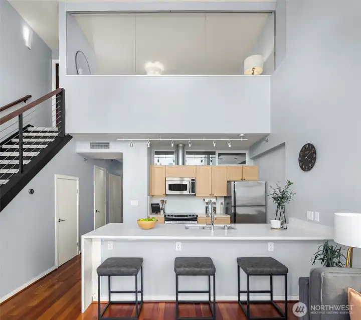 Modern kitchen features a 12 ft island with quartz countertops and breakfast bar seating