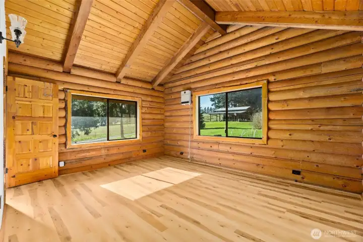 Two windows bring nature in while beautifully showcasing the warmth of the log interior.
