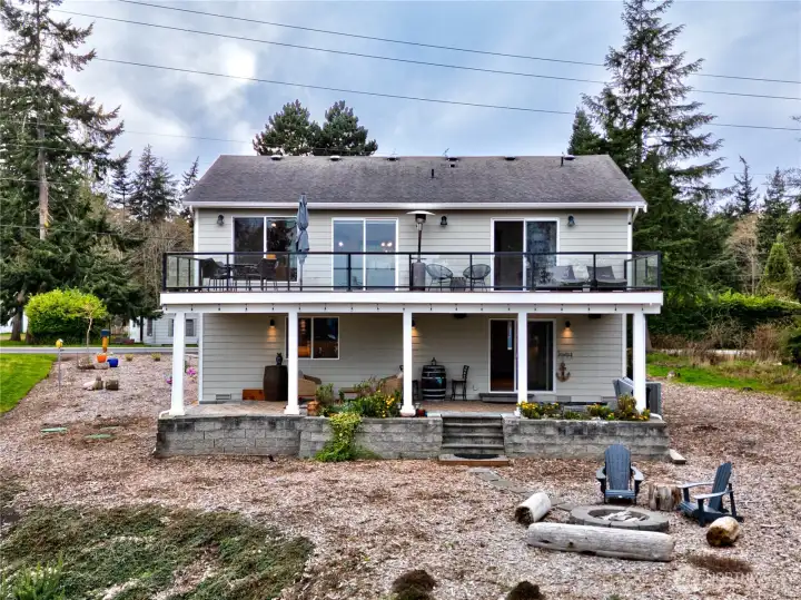 Cozy coastal home with outdoor entertaining space, oversized deck, covered patio, low-maintenance landscaping.