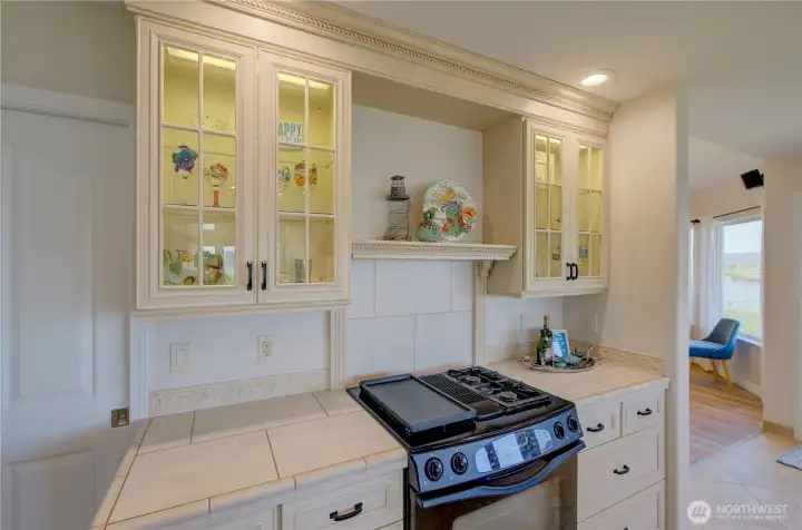 THE AMBIENCE OF THE GLASS, LIT CUPBOARDS ACCENTUATES THE NESBITT ARTWORK.