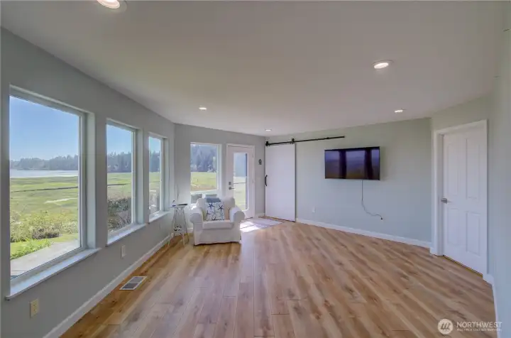 LARGE PRIMARY BEDROOM WITH WALL OF WINDOWS, PRIVATE ACCESS TO BACKYARD, WALK-IN CLOSET W/BARN DOOR AND PRIMARY BATH