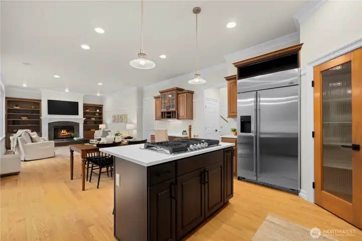 Kitchen island with breakfast bar and pantry with glass door.