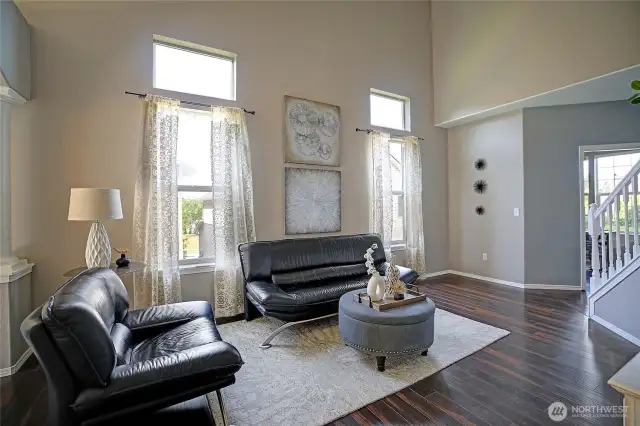 A view of the living room looking back toward the office and front entrance foyer.  The office/den can be seen through the doorway in the background.