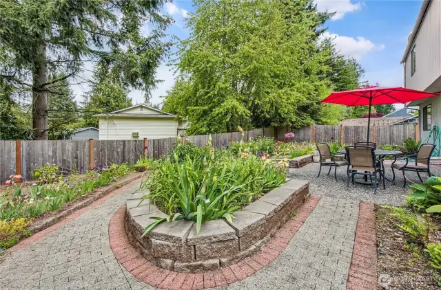 Professionally landscaped with paver bricks and raised beds make this backyard low maintenance.