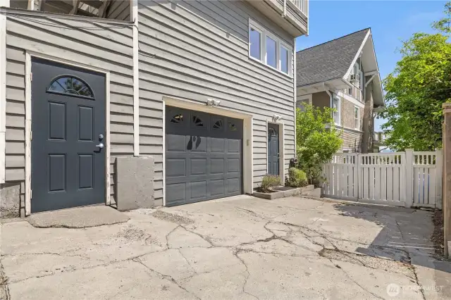 Parking pad with access to the house and a large storage room (door to the left of the garage).