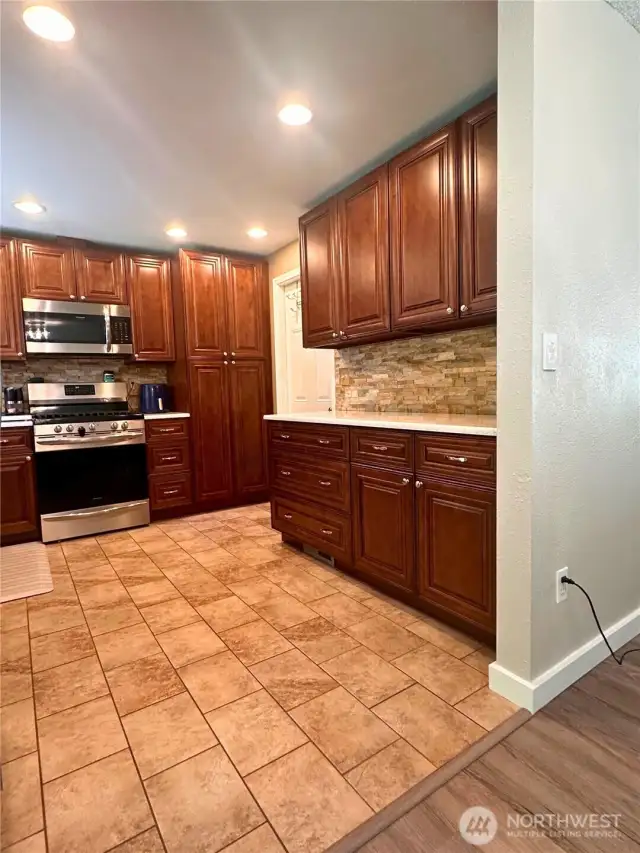 Lots of cabinets, gas stove and built in microwave. Notice the beautiful stone work.