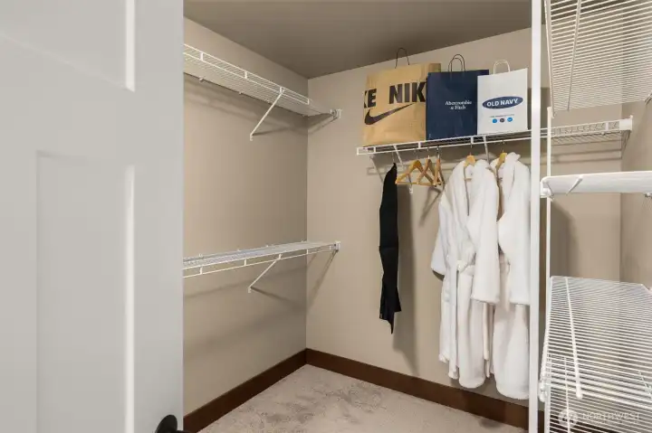 A large walk-in closet provides ample hanging space and shelving.