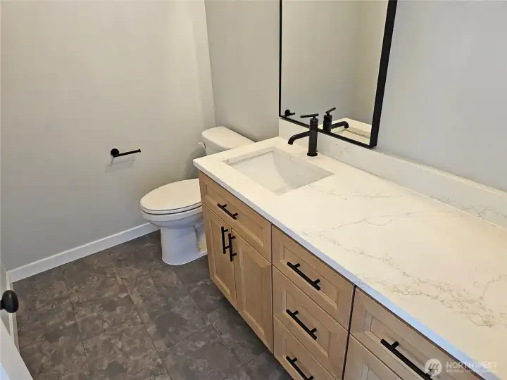 Ample vanity counter space and storage cabinetry in 2nd bath