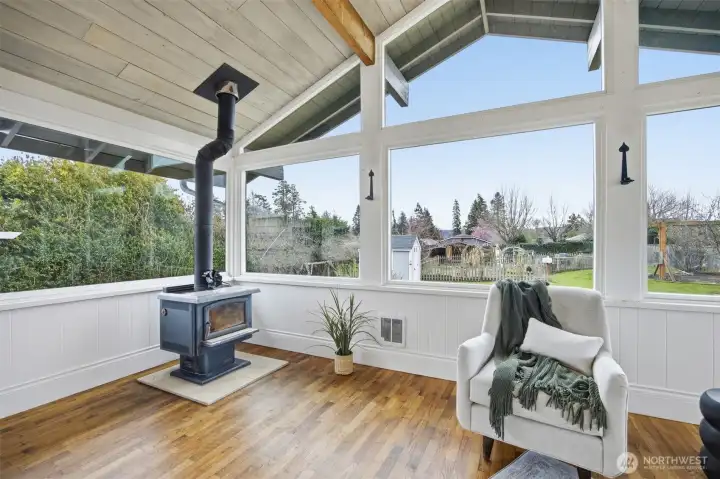 The sunroom also has hardwood floors and looks out the the flat rear yard, that is fully fenced, and has a garden area with a picket fence around it.