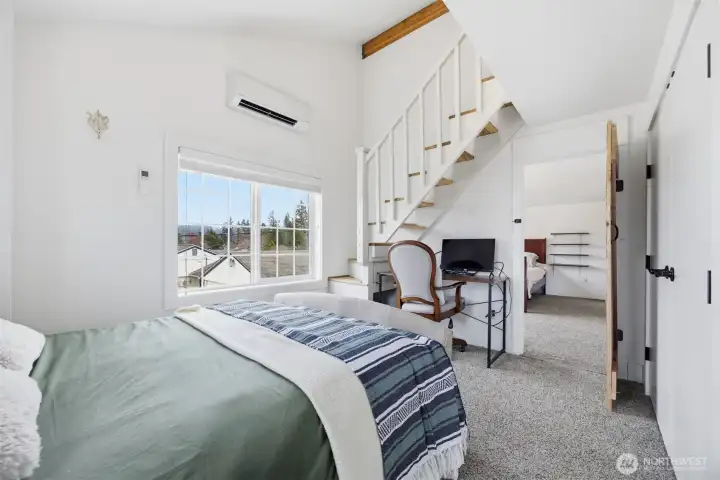 Looking across the upper north bedroom toward the stairs to the loft and the other upper bedroom with the door open between.