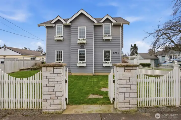 The curb appeal for this house is incredible! The picket fence, set off by the stone corner posts, the window planter boxes, and just the charming architecture of the garage and family room addition.