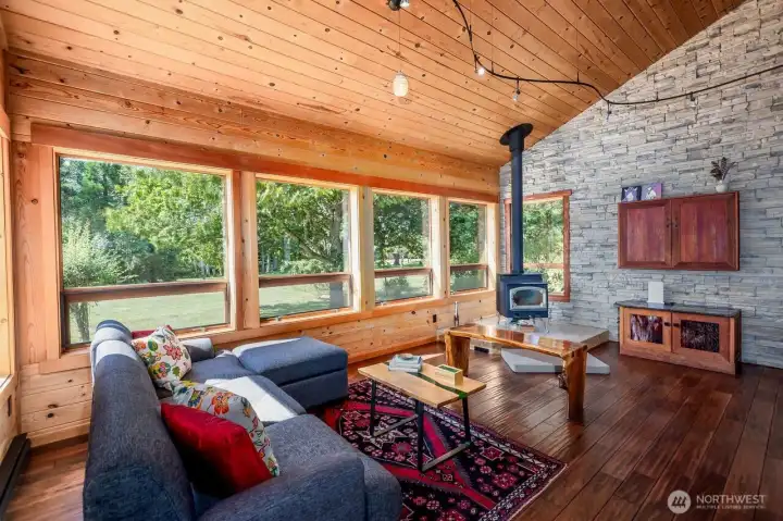 Great room overlooks field. Wood stove provides ample heat. Custom build TV cabinet on wall conceal TV.