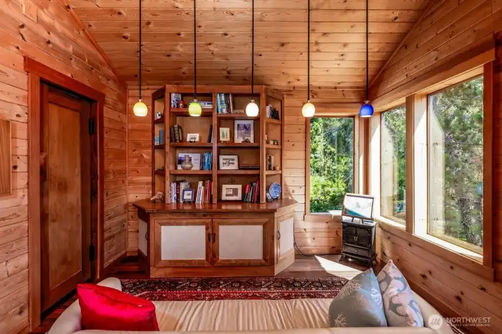 Primary bedroom has custom built credenza. Seating space provides a reading area.