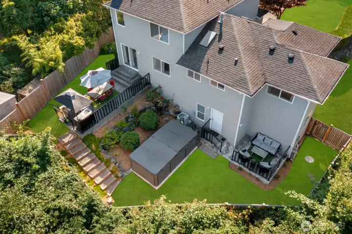 Expansive back yard w/ outdoor kitchen, multiple entertaining areas, Swim Spa & garden beds