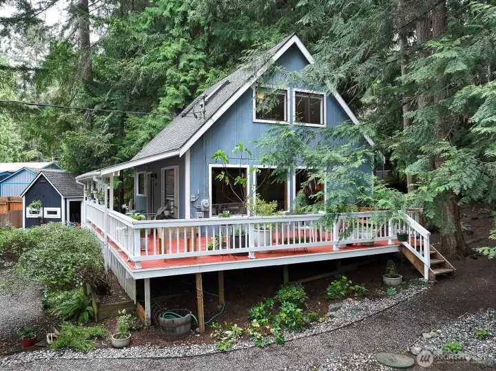Southern side of home. This photo reflects the generously sized windows and expanse of the deck. Low maintenance landscaping.