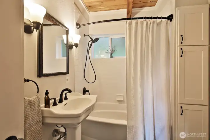 Full bath with built in storage cabinets. Floor is ceramic tile.