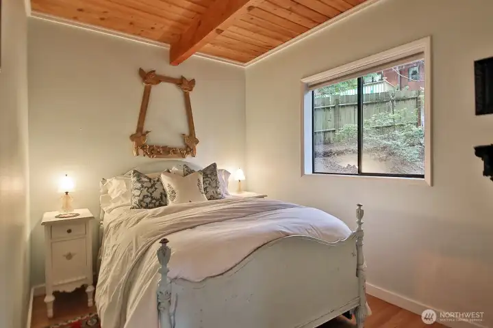 Main level bedroom which looks out upon the eastern side of the home.