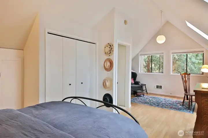 Open doorway beyond the hats is to the stairs. Windows and skylights bring in the natural light.