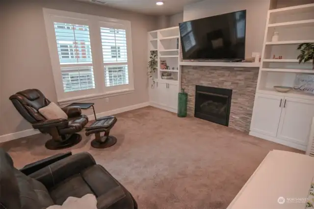 Large living space with beautiful build-in cabinets surrounding the gas fireplace.