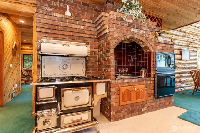 6 burner propane stove and propane grill under glasses in brick surround.