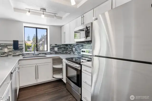 This bright white kitchen boasts of quartz countertops and stainless steel appliances.