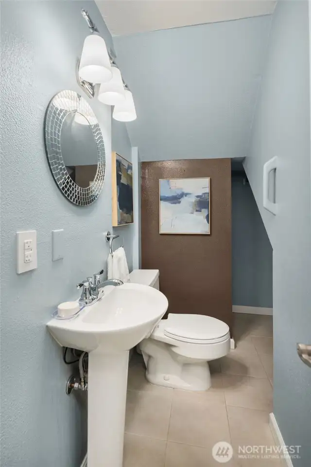 Convenient half bath on main level includes extra storing shelving around the corner..