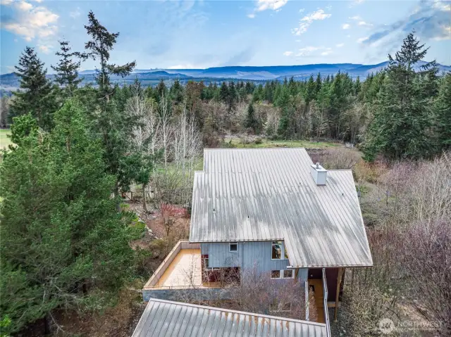 This listing combines two adjacent tax parcels. This view looks over the roof of the house. The trees downhill from the house are on this property and could open up the mountain view. The adjacent parcel is to the right of this parcel. In the next photos, I will start each with the address of 1221 for the house parcel and 1291 for the outbuilding property.