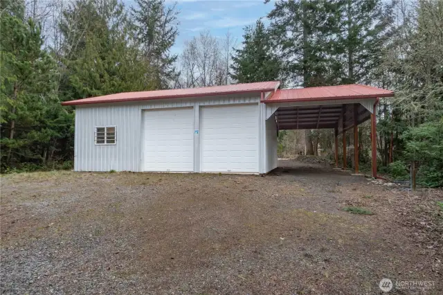 1291. View of the outbuilding from a separate driveway. A view of the outbuilding from a separate driveway, featuring an attached tall carport.