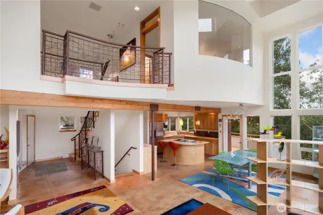 1221. All those curves! View shows the front hall entry with stairs leading upstairs. Interesting hand-forged railing by a local metalsmith. Stairs leading downstairs b1221. Just look at those stunning curves! The entryway showcases a beautiful staircase leading upstairs, complete with a unique hand-forged railing made by a talented local metalsmith. You’ll find additional stairs that take you down, nestled perfectly between the entry and the kitchen. The upstairs primary bedroom is graced with amazing windows that fill the space with natural light.etween the entry and the kitchen. Love the windows upstairs for the primary bedroom.