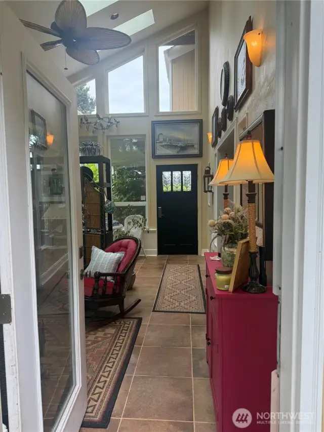 Looking at the front door through the back patio door. Ceiling fan noted.