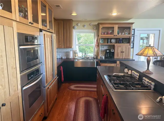 Propane Jenn-air cooktop. KitchenAid electric combo convection oven and convection microwave. Stainless steel farm sink. Jenn-air refrigerator with cabinet panels and KitchenAid stainless steel interior dishwasher with cabinet panels. Display cabinets with lightiing.