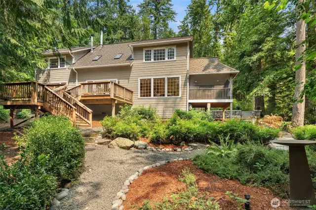 The southern side of the home has serene views of the forest from inside the home, or on a sunny day, your expansive deck. This sweet path meanders around the front yard.