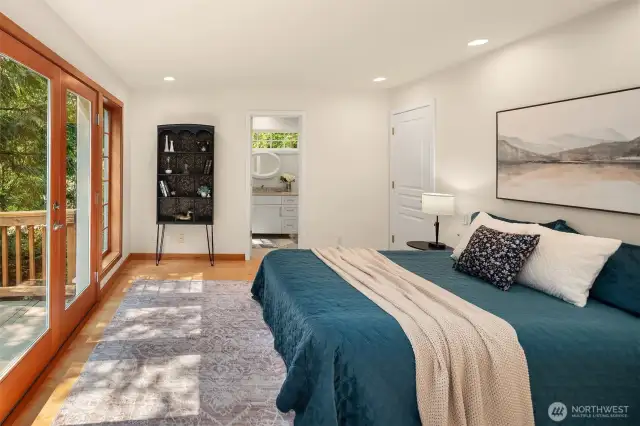 The ensuite primary is just off the LR, behind a hidden door. Dual walk-in closets, french doors to the deck and a tiled bathroom.