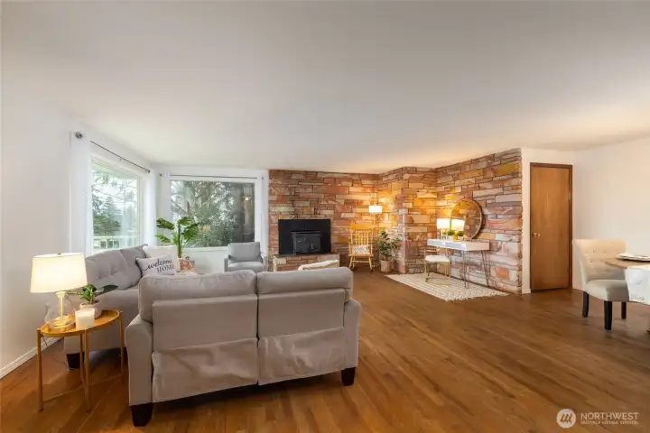Welcoming great room with hardwood flooring, stunning masonry, wood burning insert, room for a desk or piano and dining. (staged)