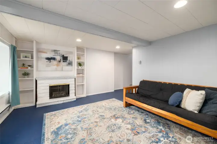 Family room is located on the lower level. Concrete floors and built-in shelving plus an exterior entrance.