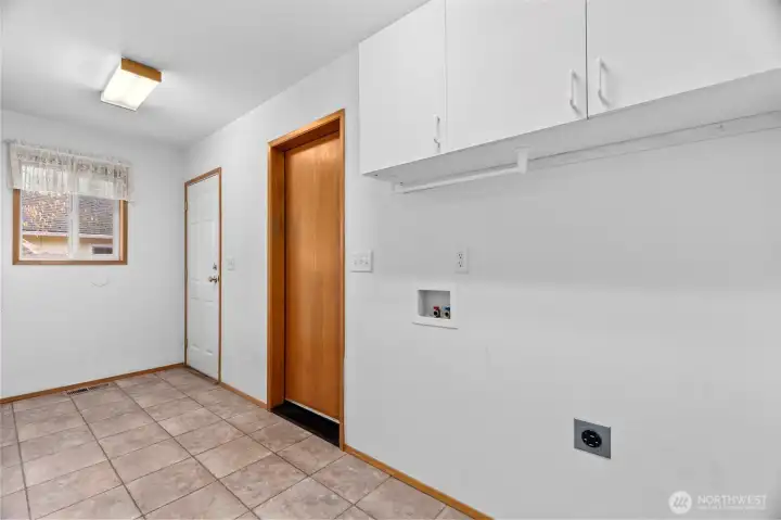 Laundry area with extra storage. Doors to garage and patio